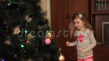 两个微笑的小女孩在家里的新年树上装饰圣诞装饰品。 圣诞树用冷杉锥。 新
